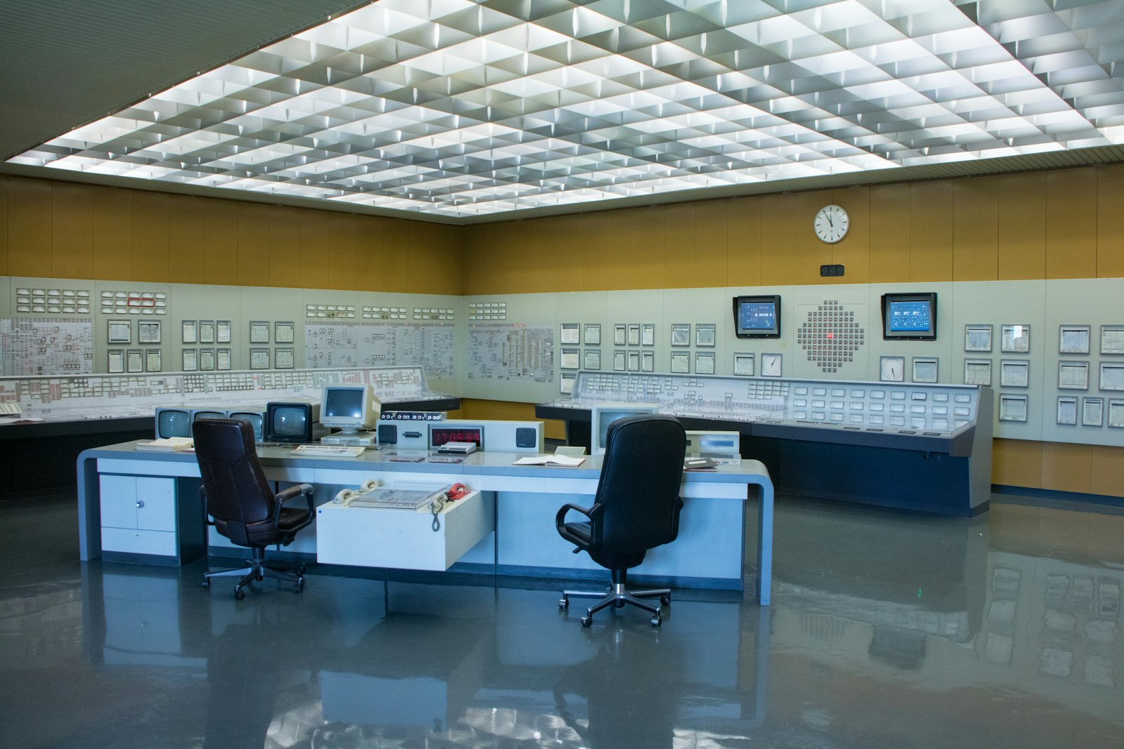 Una sala de control industrial vacía, rodeada de paneles de instrumentos